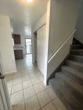 Staircase featuring tile patterned flooring and a textured ceiling