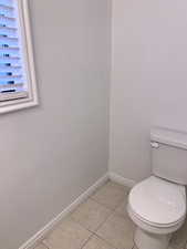 Bathroom with light tile patterned flooring and baseboards