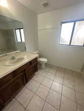 Full bathroom with vanity, a textured ceiling, and light tile patterned floors