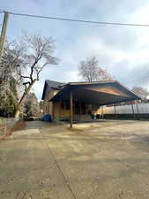 View of car parking featuring concrete driveway and a carport