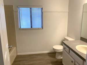 Full bathroom featuring vanity, dark wood-style floors, and bathing tub / shower combination
