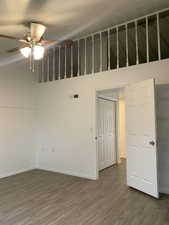 Unfurnished room with dark wood-type flooring and ceiling fan
