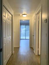 Hall featuring a textured ceiling and wood finished floors