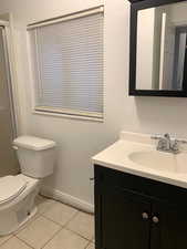 Full bath with vanity, light tile patterned floors, and an enclosed shower