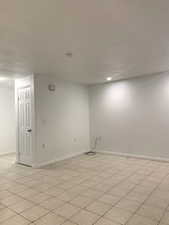 Unfurnished room with light tile patterned floors and a textured ceiling