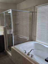 Full bathroom featuring a shower stall, vanity, and a garden tub