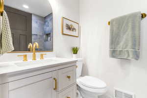 Half bathroom with vanity and toilet