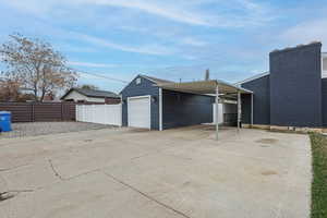 Garage featuring driveway and a carport