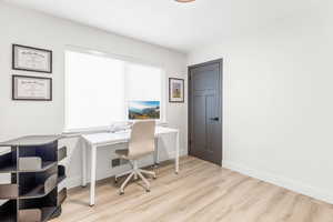 Office space with light wood-style floors and baseboards