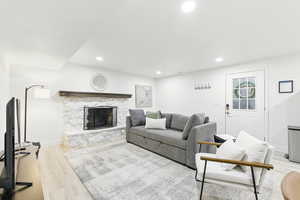 Living area with a fireplace, light wood finished floors, and recessed lighting