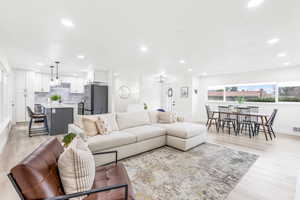 Living room featuring plenty of natural light, light wood-type flooring, and recessed lighting
