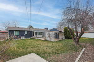 Rear view of property with a patio area, brick siding, and roof with shingles