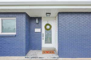 View of exterior entry featuring brick siding