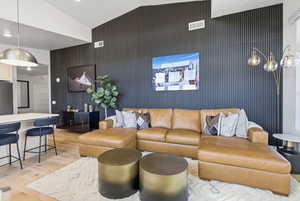 Living area with light wood-style flooring, lofted ceiling, and recessed lighting