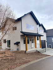 View of front of home with a porch and concrete driveway