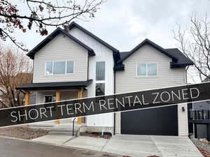 View of front of property with board and batten siding, an attached garage, driveway, and a porch