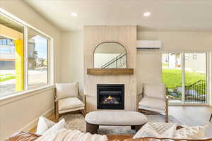 Living area with a fireplace, wood finished floors, and recessed lighting