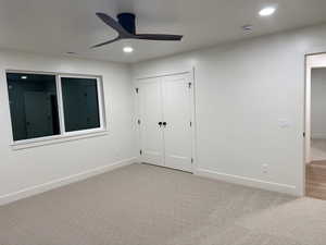 Unfurnished bedroom with light colored carpet, recessed lighting, a closet, and a ceiling fan