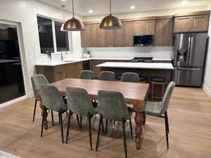 Kitchen with stainless steel appliances, tasteful backsplash, pendant lighting, recessed lighting, and light wood-style flooring