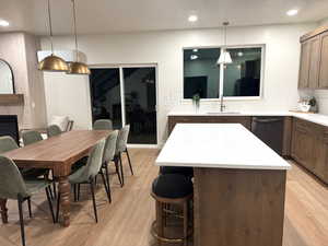 Kitchen with a center island, backsplash, dishwasher, light wood-style floors, and recessed lighting
