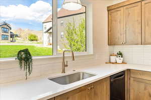 Kitchen featuring dishwasher, decorative backsplash, light stone counters, a mountain view, and wood finish cabinetry