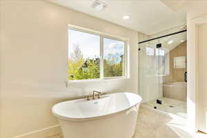 Bathroom featuring a shower stall, a freestanding bath, recessed lighting, and light tile patterned flooring