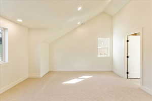 Bonus room with lofted ceiling, light carpet, and recessed lighting