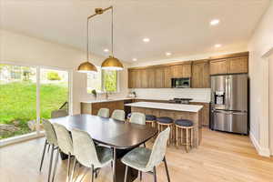 Dining space with light wood finished floors and recessed lighting
