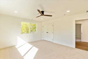 Unfurnished bedroom featuring light carpet, ceiling fan, recessed lighting, and a closet