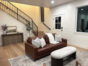 Living area featuring wood-type flooring, stairs, and recessed lighting