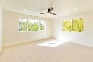 Unfurnished room with light carpet, plenty of natural light, a ceiling fan, and recessed lighting