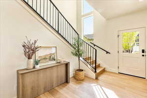 Foyer entrance featuring light wood-style floors and a high ceiling