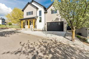 View of front of home featuring board and batten siding, driveway, a garage, and a porch
