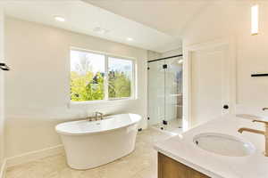Full bath with a stall shower, a freestanding tub, and double vanity