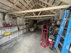Miscellaneous room with lofted ceiling and unfinished concrete flooring