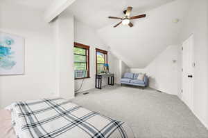 Bedroom with vaulted ceiling, a ceiling fan, and carpet flooring
