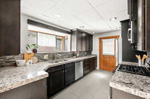 Kitchen featuring plenty of natural light, a drop ceiling, appliances with stainless steel finishes, recessed lighting, and dark brown cabinetry