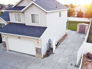 View of front of house with roof with shingles, stucco siding, an attached garage, and driveway