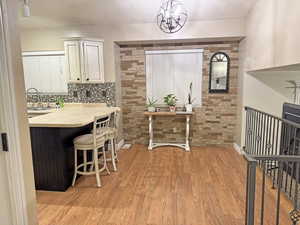 Dining space with light wood-style floors and a chandelier