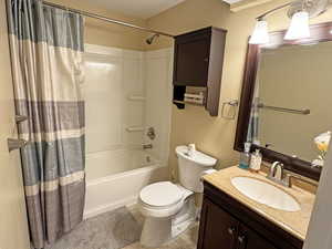 Bathroom featuring vanity, shower / bathtub combination with curtain, and light tile patterned flooring