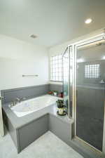 Full bath featuring a whirlpool tub, a shower stall, light tile patterned floors, and recessed lighting