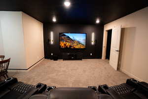 Home theater with light carpet and baseboards
