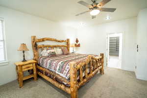 Bedroom featuring carpet, a ceiling fan, and a spacious closet