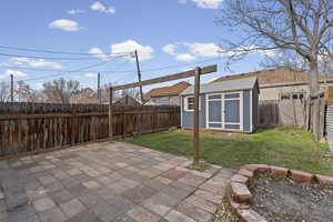 Fenced backyard with a patio area and a shed
