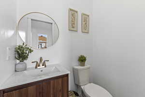 Half bathroom featuring vanity and toilet