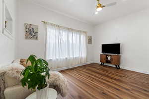 Living room featuring a ceiling fan and dark wood-style floors
