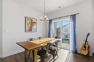 Dining space featuring a chandelier and dark wood-type flooring