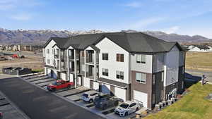 View of building exterior with a mountain view, an attached garage, and driveway