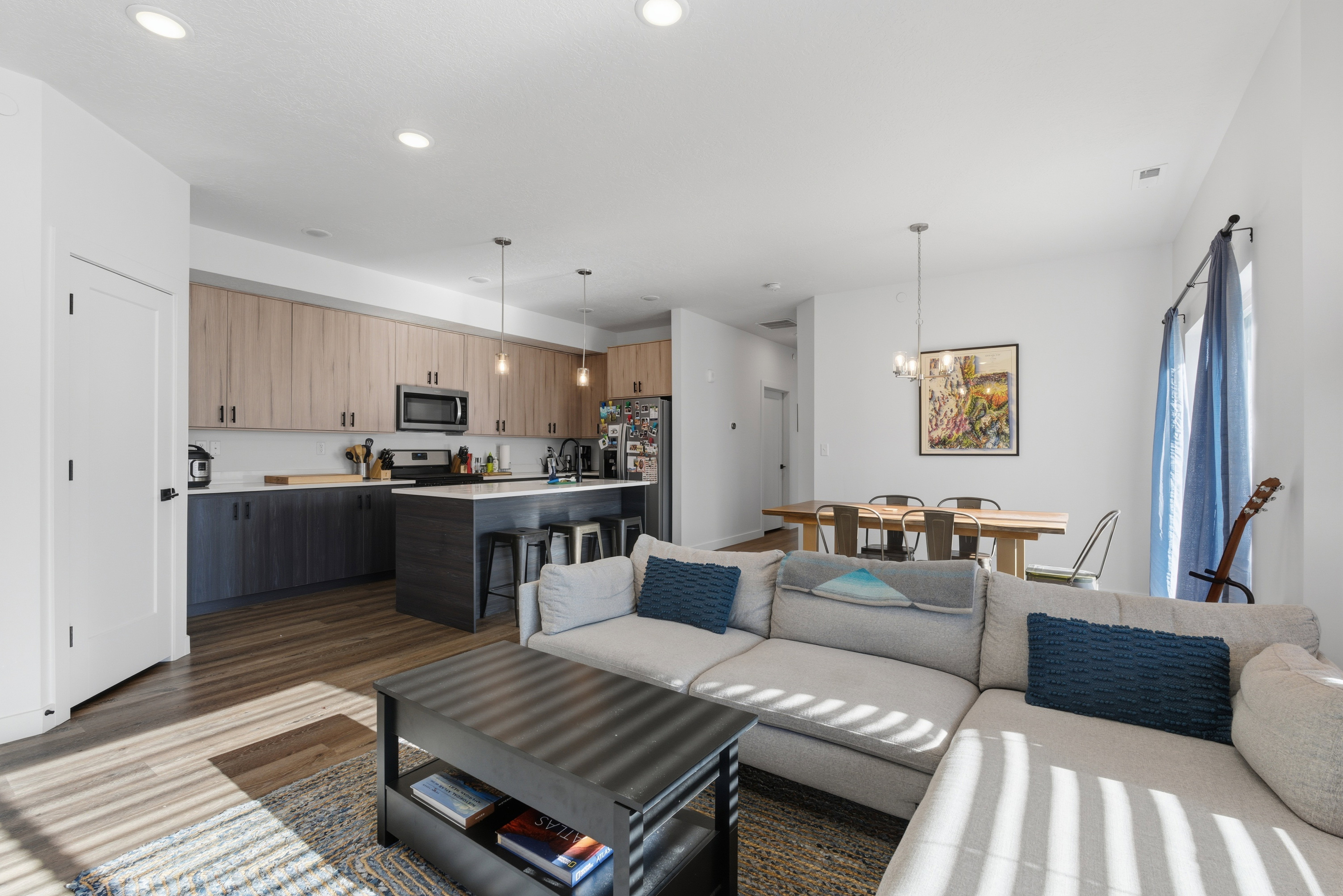 Living area featuring dark wood-style flooring, a chandelier, and recessed lighting