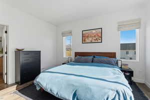 Bedroom with wood finished floors and baseboards